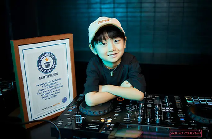 dj rinoka in front of console with record certificate