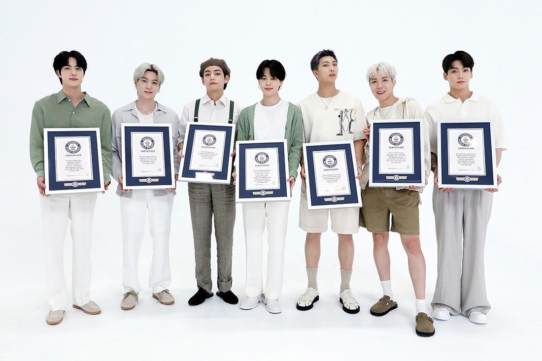BTS holding their guinness world records certificate